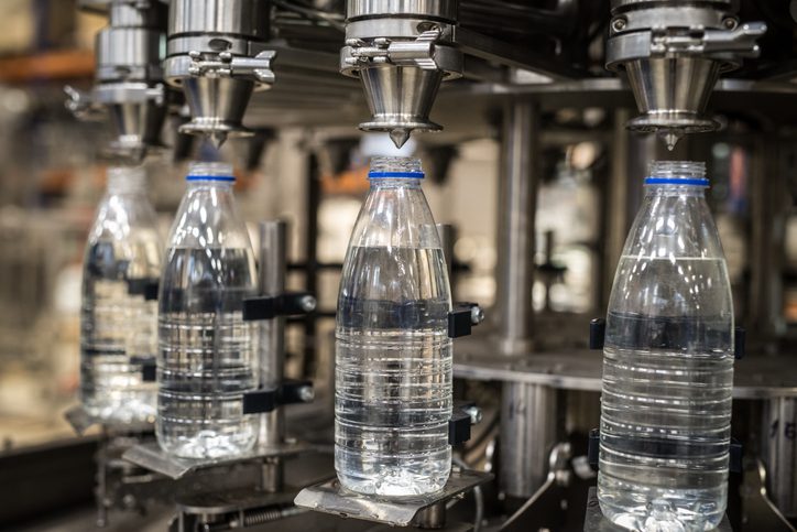 Bottles being filled with water by a machine