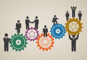 Business people standing on gears