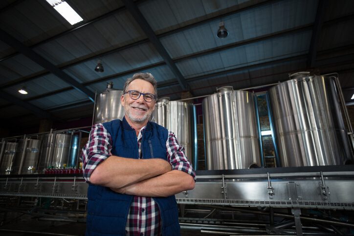 Man standing in front of brewing equipment