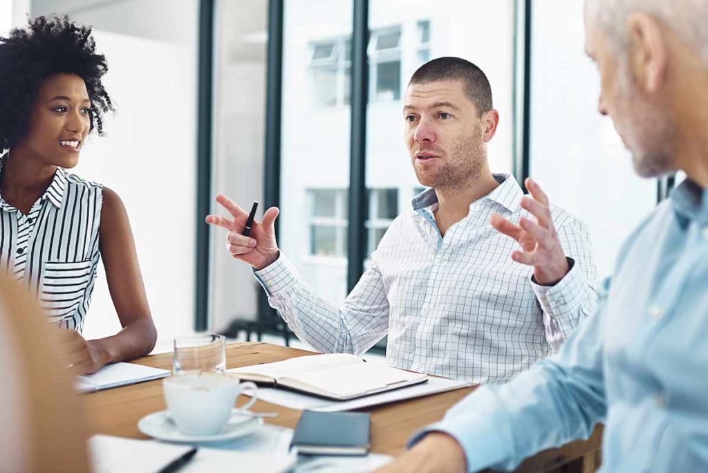 Two men and a woman meeting in office